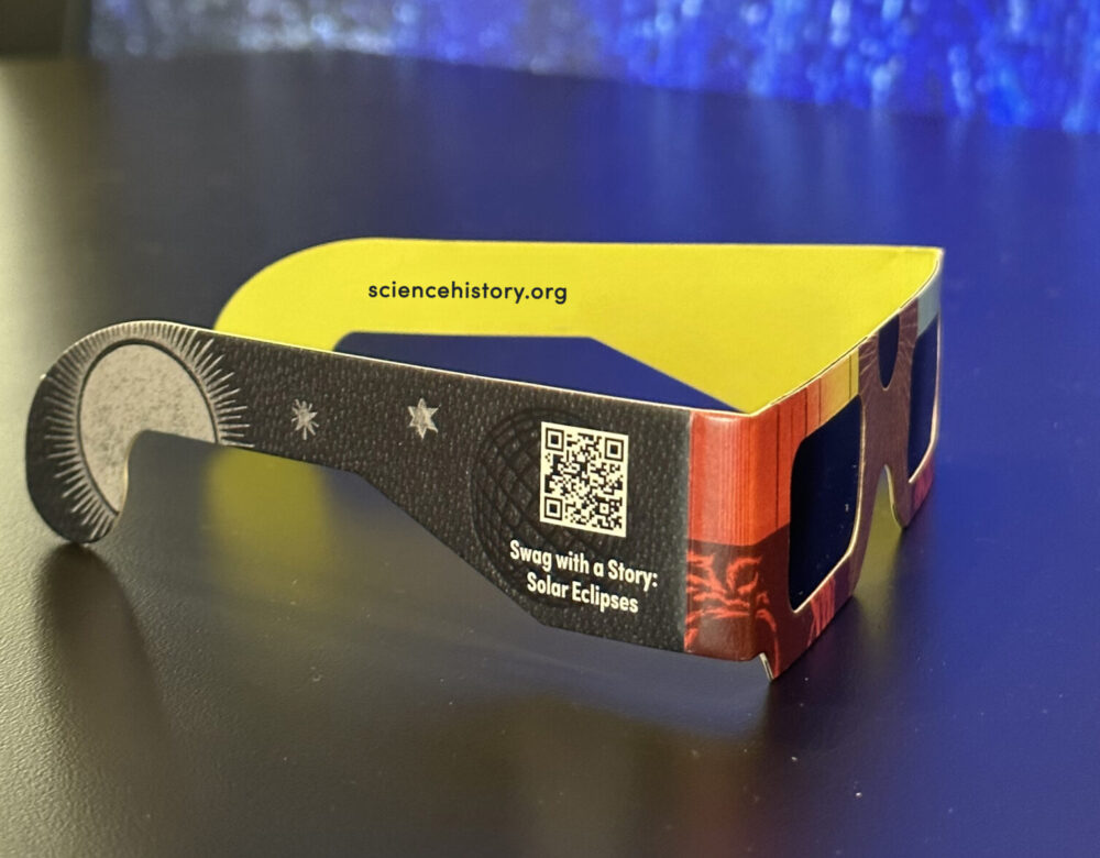 side view of colorful pair of eclipse glasses on a table in the museum gallery